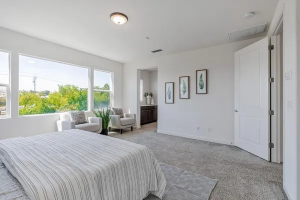 a bedroom with a large bed and a potted plant
