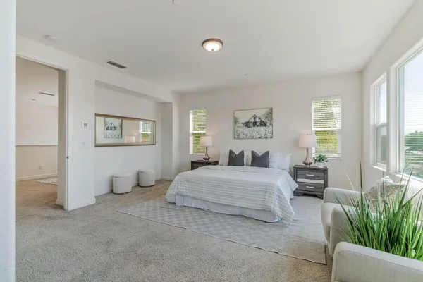 a bedroom with a bed and a large window