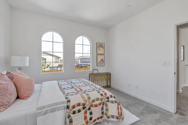 a bedroom with a bed potted plant and a window