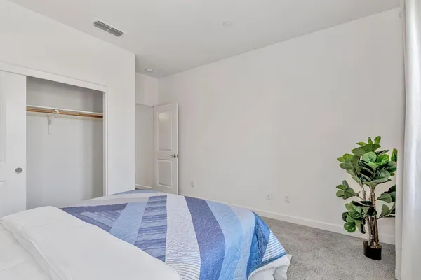 a bedroom with a large bed and a potted plant