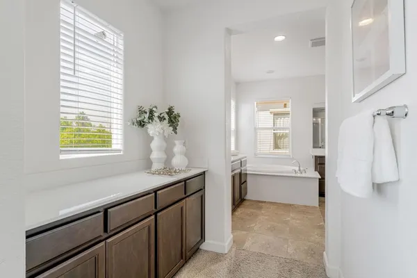 a large bathroom with a large tub sink and mirror