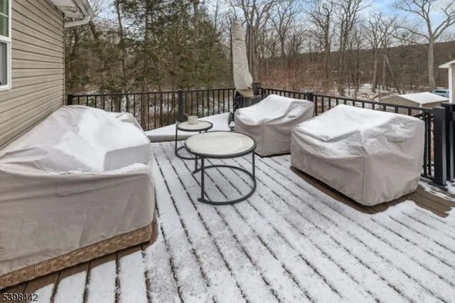 a view of a patio with couches table and chairs with wooden floor and fence