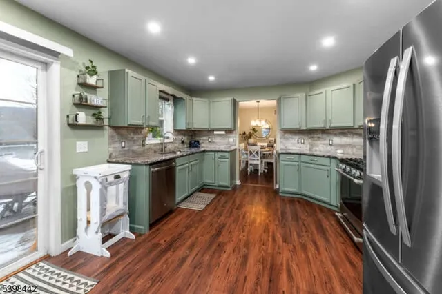 a kitchen with kitchen island granite countertop stainless steel appliances cabinets a sink and a counter top space