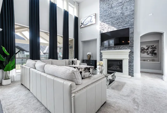 a living room with furniture a flat screen tv and a fireplace