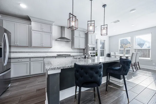 a kitchen with stainless steel appliances granite countertop wooden floors and white cabinets