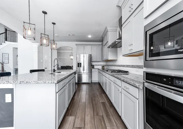 a large kitchen with stainless steel appliances granite countertop a stove a sink and a refrigerator