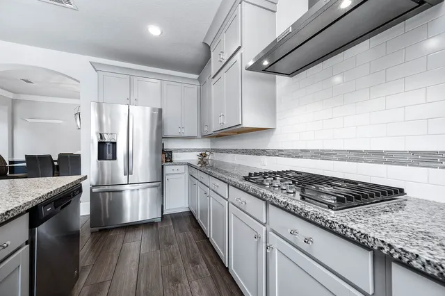 a kitchen with granite countertop a refrigerator and a sink