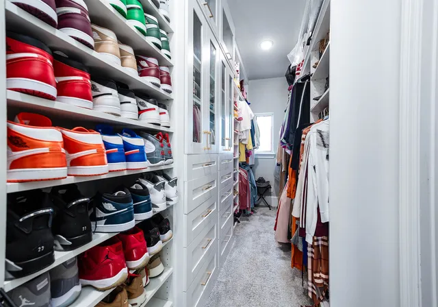 a view of walk in closet with clothes and shoes