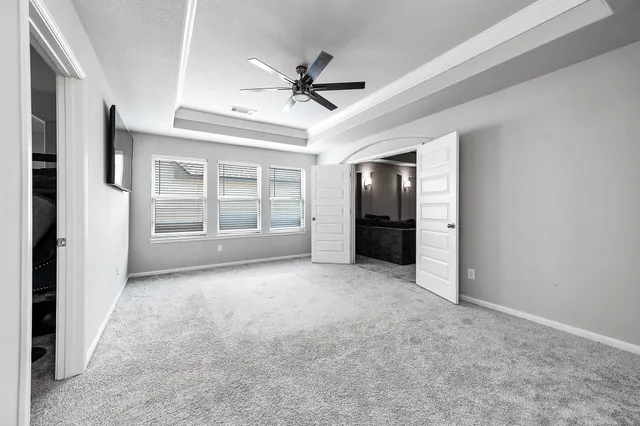 an empty room with a empty space ceiling fan and windows