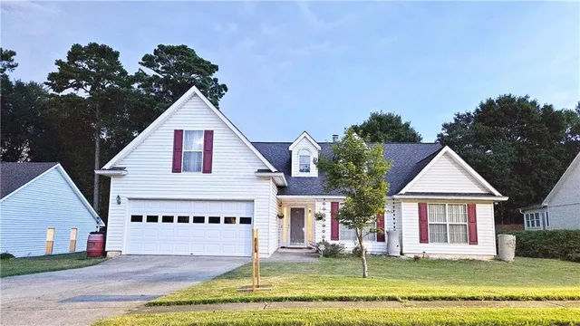 a view of a house with a yard and potted plants