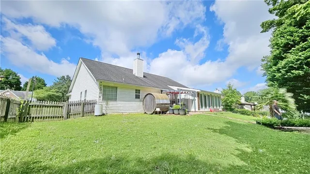 a view of a house with a big yard and a large tree