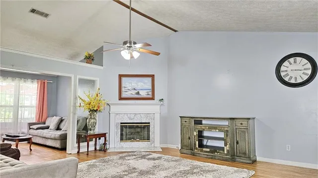 a living room with furniture a chandelier and a fireplace