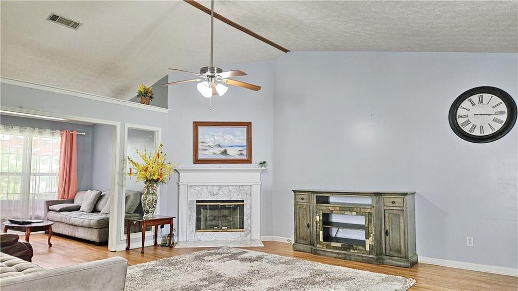 2233 Hansford Pass Buford, GA 30519 - Photo 18 of 45 a living room with furniture a chandelier and a fireplace