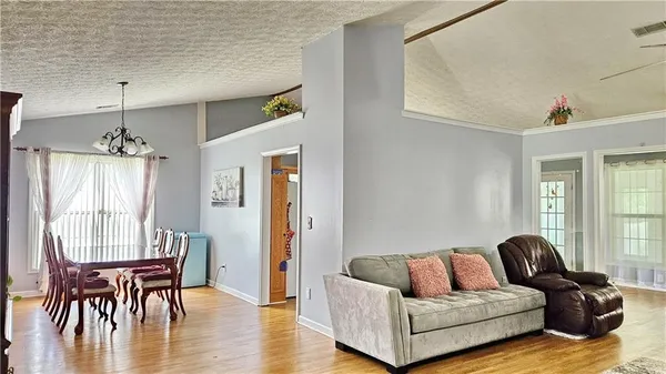 a living room with furniture wooden floor and a chandelier