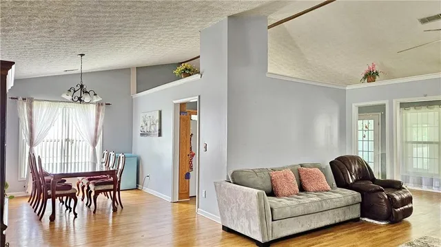 a living room with furniture wooden floor and a chandelier