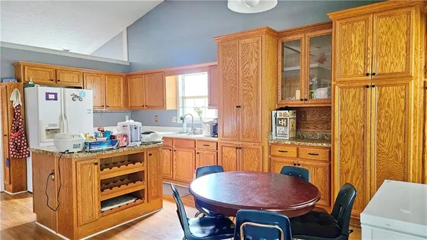 a kitchen with stainless steel appliances a stove a refrigerator a sink dishwasher with a dining table and chair