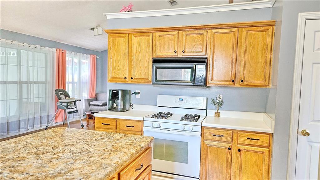 2233 Hansford Pass Buford, GA 30519 - Photo 26 of 45 a kitchen with a stove a sink a microwave a refrigerator and cabinets