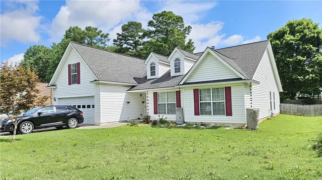 a front view of a house with a garden and plants