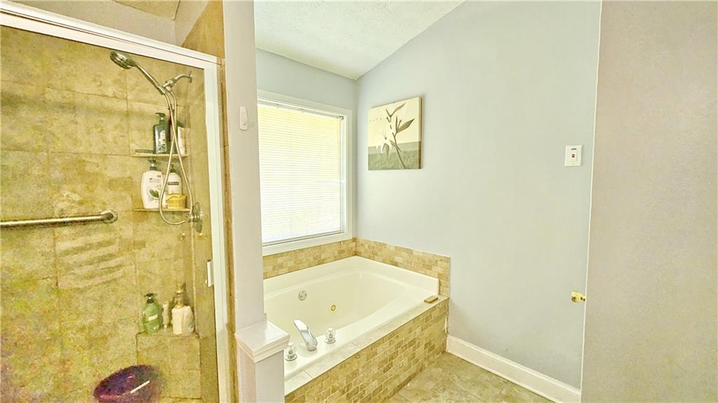 2233 Hansford Pass Buford, GA 30519 - Photo 37 of 45 a bathroom with a tub and shower
