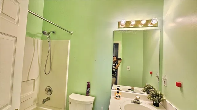 a bathroom with a sink and mirror with bathtub
