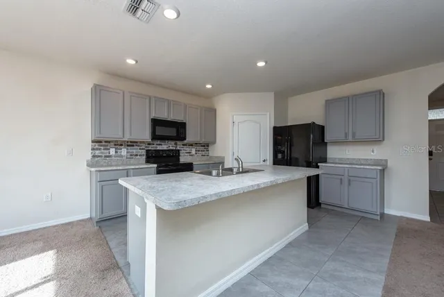 a kitchen with a sink a stove top oven and white stainless steel appliances