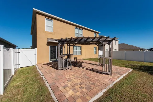 a view of a house with backyard and sitting area