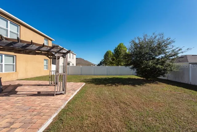 a view of a house with backyard and trees