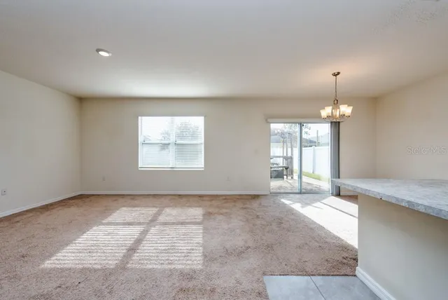 an empty room with windows and chandelier