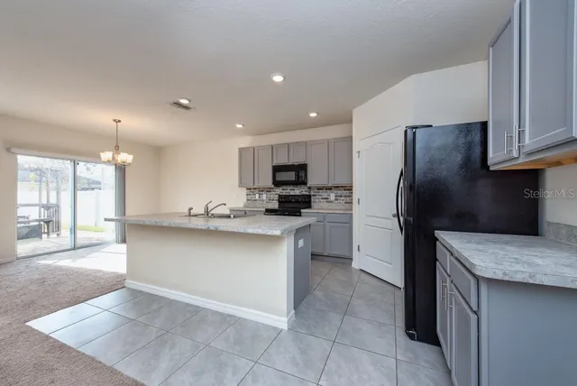 a kitchen with stainless steel appliances granite countertop a refrigerator a sink a stove and oven