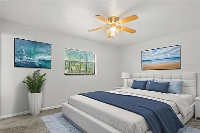 a bedroom with a large bed and a potted plant