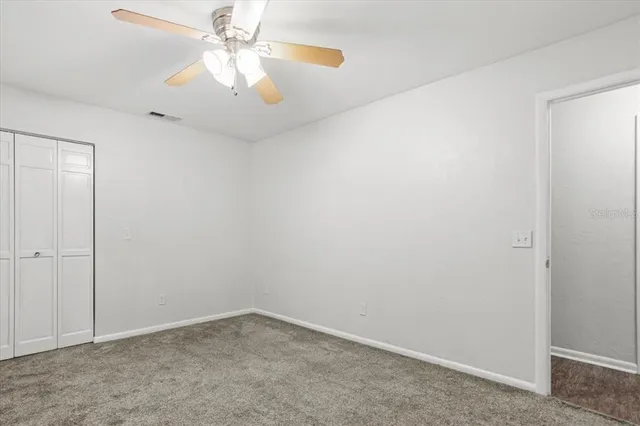an empty room with chandelier fan
