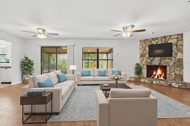 a living room with furniture a fireplace and a large mirror