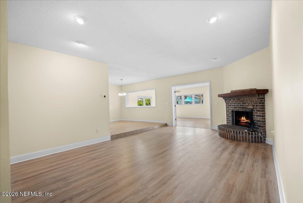 4201 San Pablo Road South Jacksonville, FL 32250 - Photo 13 of 50 an empty room with wooden floor and a fireplace