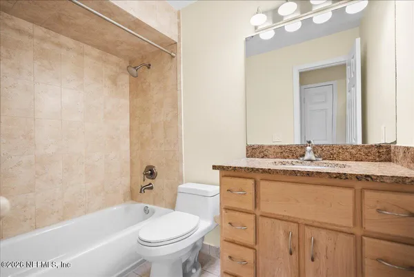 a bathroom with a granite countertop toilet a sink and a bathtub