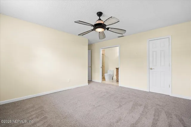 a view of empty room with a fan and a ceiling fan