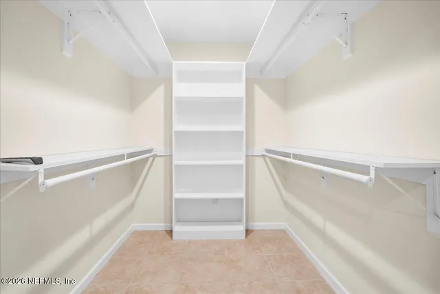 a view of walk in closet with empty racks