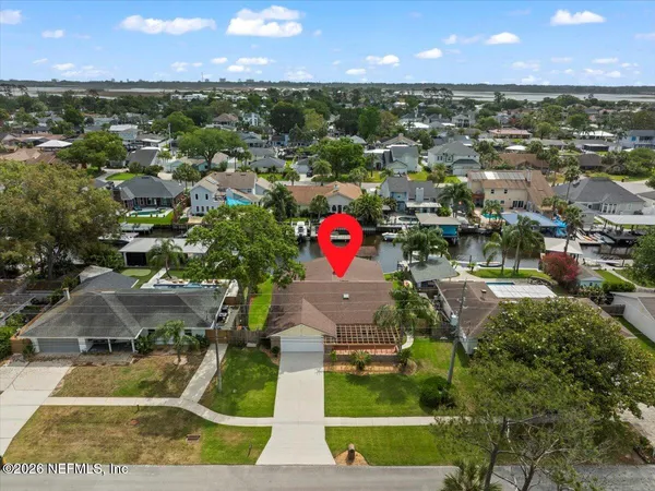 an aerial view of residential houses with outdoor space and trees