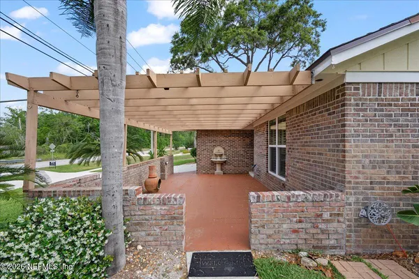a view of a patio with table and chairs potted plants and large tree