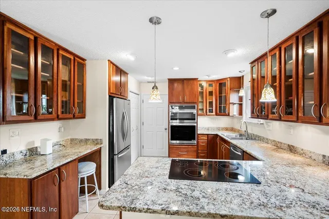 a kitchen with stainless steel appliances granite countertop a sink stove and refrigerator
