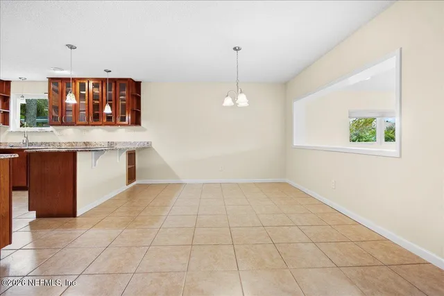 a view of kitchen with granite countertop cabinets next to a window