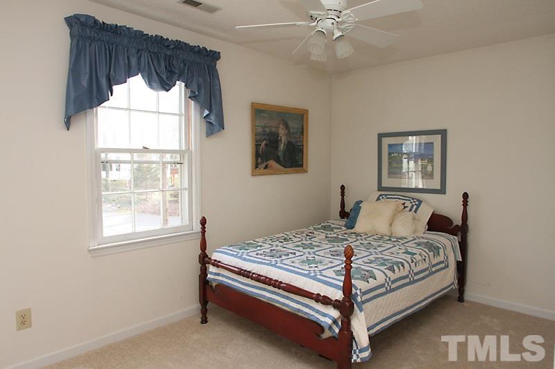 4901 Kinross Court Raleigh, NC 27613 - Photo 15 of 18 a bedroom with a bed and window