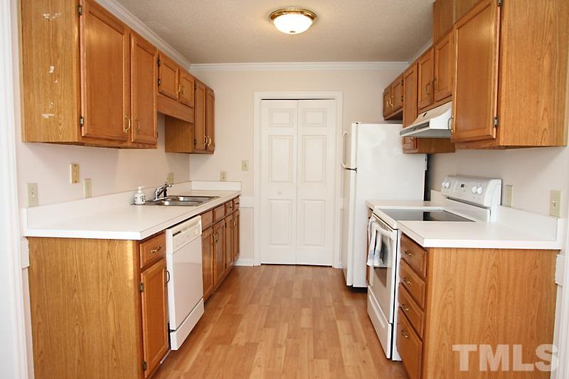 4901 Kinross Court Raleigh, NC 27613 - Photo 8 of 18 a kitchen with a sink stove top oven and cabinets
