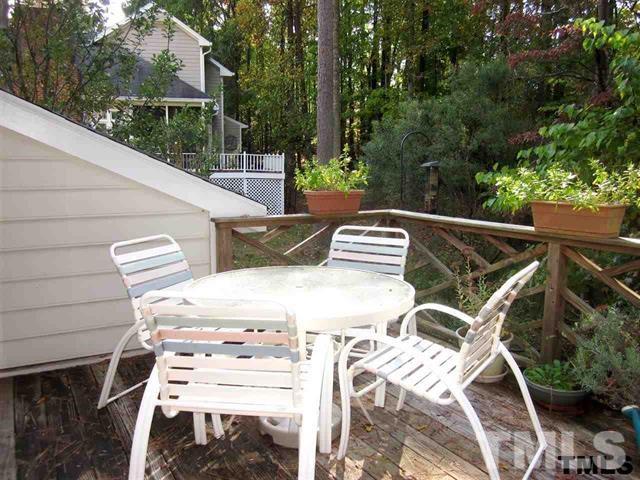 4901 Kinross Court Raleigh, NC 27613 - Photo 9 of 18 a view of a patio with table and chairs with wooden floor and fence