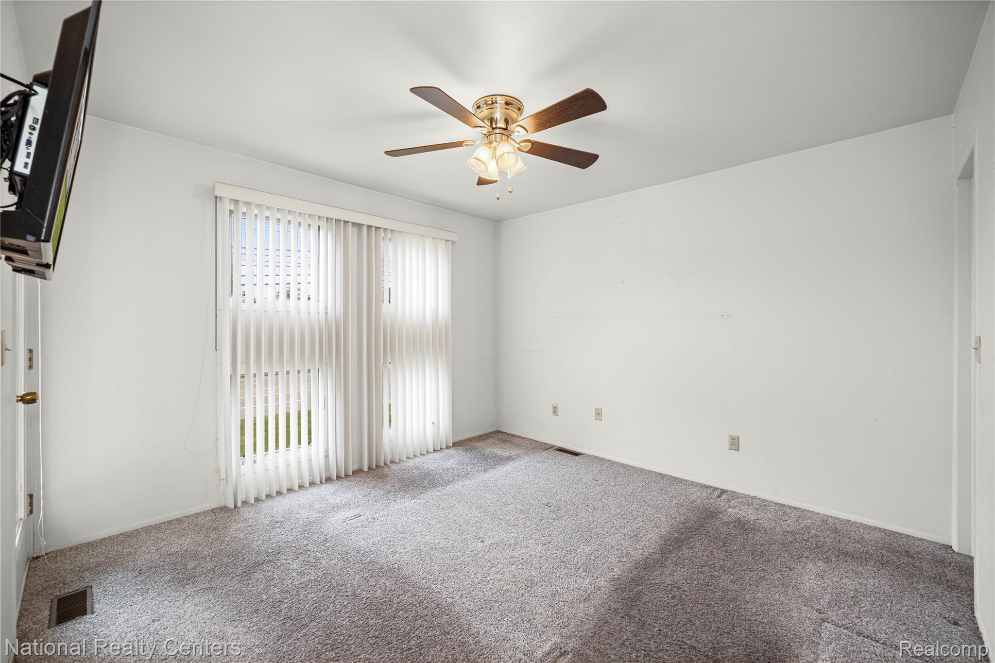 5274 East 14 Mile Road Warren, MI 48092 - Photo 18 of 31 Ceiling fan with light fixture, vertical blinds, and wall-to-wall carpeting