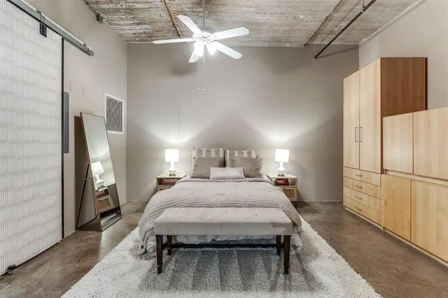 a bedroom with a bed and a refrigerator