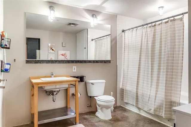 a bathroom with a sink a toilet and a mirror