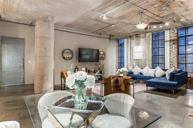 a living room with furniture fireplace and a large window