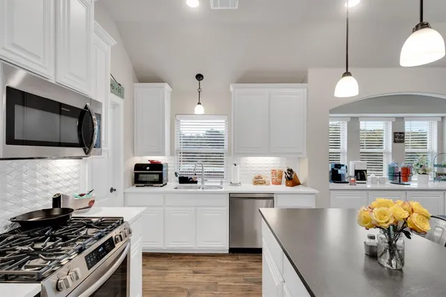 a kitchen with stainless steel appliances a stove sink microwave and cabinets