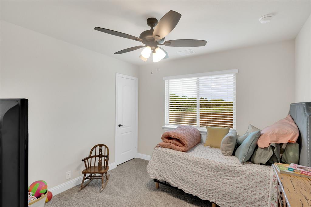 5038 Ridgehurst Lane Midlothian, TX 76065 - Photo 24 of 37 a bedroom with a bed and a chandelier