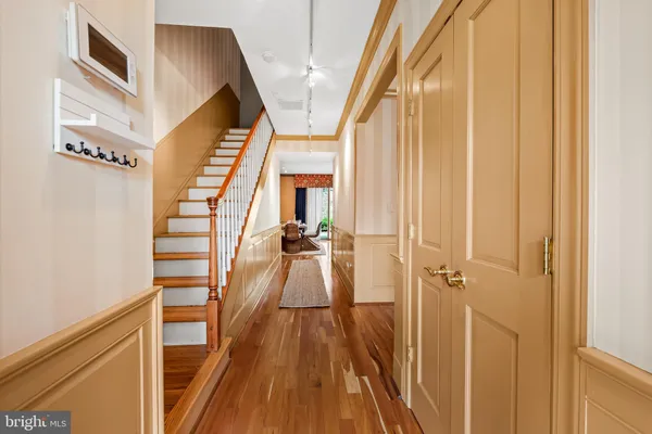 a view of a hallway with wooden floor and staircase